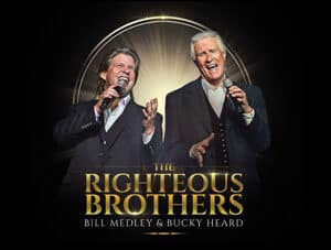 Image of the Righteous Brothers standing with microphones with their text logo below them.
