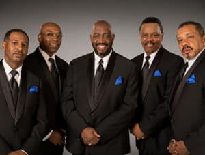 Promo Photo of the Temptations standing together in matching suits